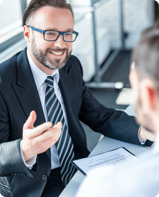 a smiling man wearing black suit and specs
