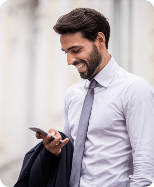 A smiling man in blue shirt looking at his phone