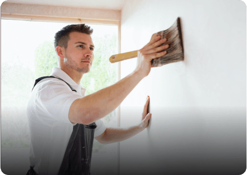 a young man painting a wall
