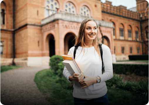 a student standing in front of a college building