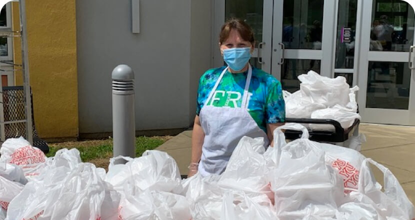 a woman wearing mask standing with all the packed food